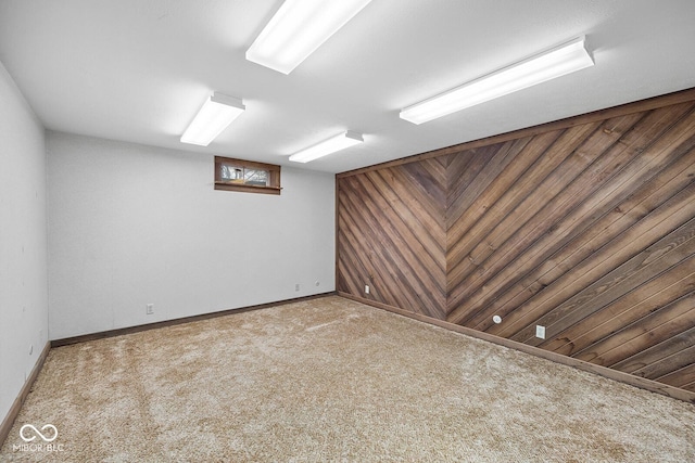 carpeted empty room with wood walls