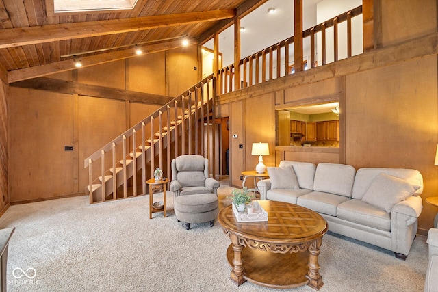 carpeted living room with beamed ceiling, wooden ceiling, high vaulted ceiling, and wood walls