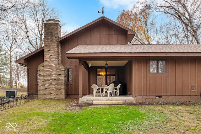 rear view of house with a patio, central AC unit, and a lawn