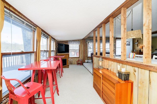 dining room featuring carpet floors and a brick fireplace