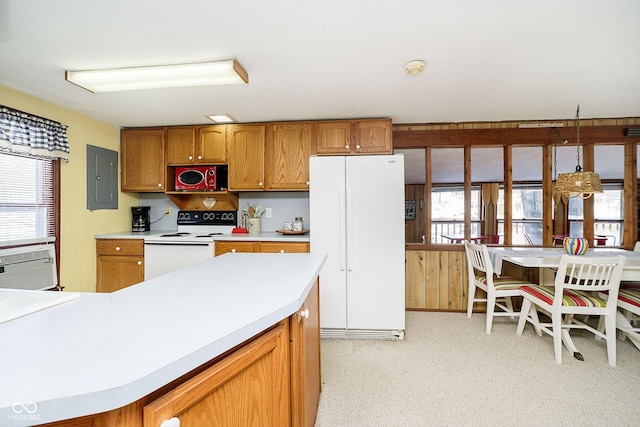 kitchen featuring a wealth of natural light, light countertops, white appliances, and brown cabinets