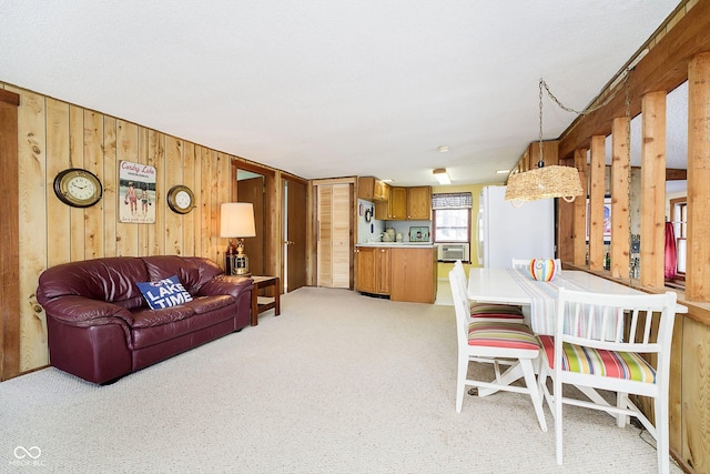 living area with wooden walls and light colored carpet