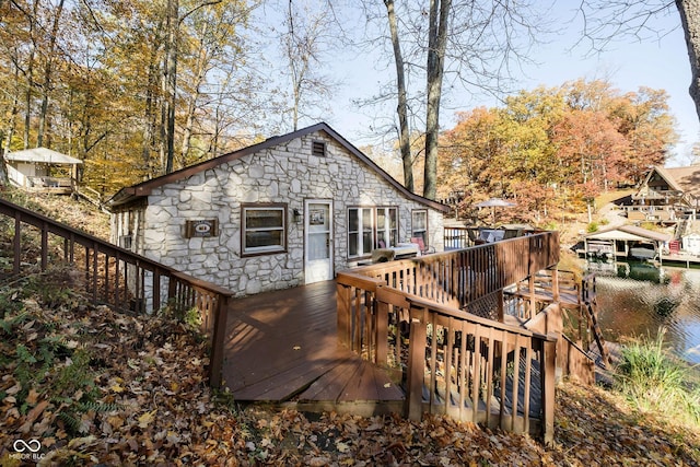 rear view of house featuring stone siding and a deck