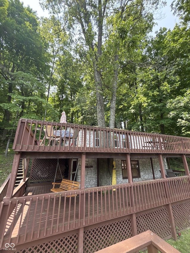 7018 Drum Dr, Nineveh, IN 46164 - rear view of house featuring stone siding, a wooden deck, stairs, and view of wooded area