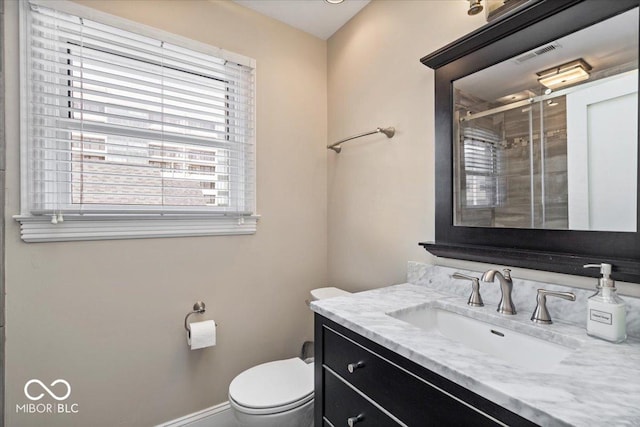 bathroom with visible vents, a shower stall, baseboards, toilet, and vanity