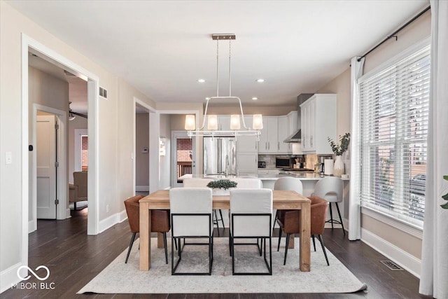 dining space featuring dark wood finished floors, visible vents, and baseboards