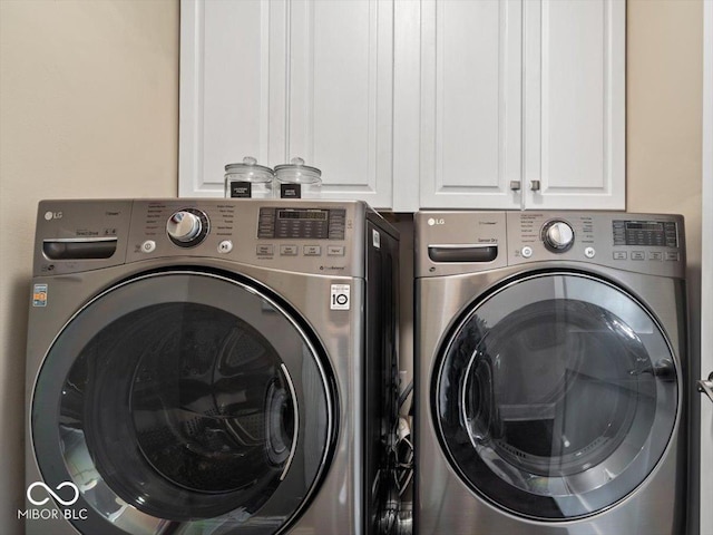 washroom with cabinet space and washing machine and dryer