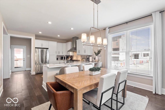 dining room featuring recessed lighting, baseboards, dark wood-type flooring, and an inviting chandelier