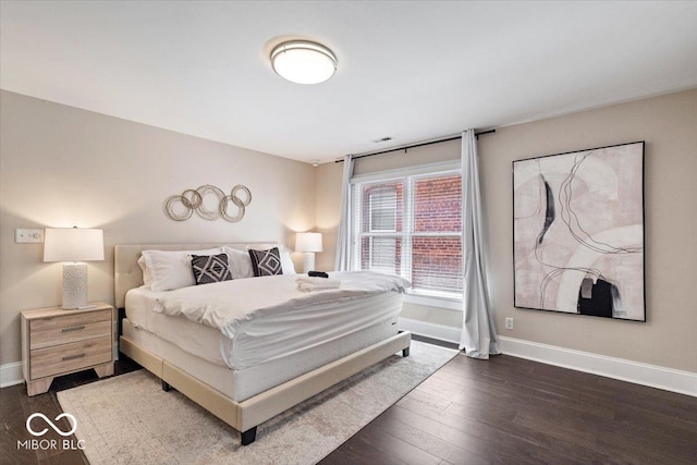 bedroom featuring visible vents, baseboards, and wood finished floors