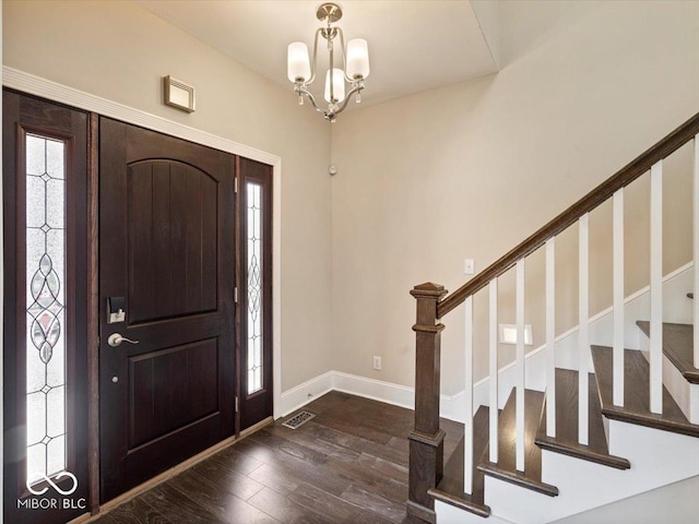 foyer entrance featuring stairway, baseboards, visible vents, dark wood-type flooring, and a notable chandelier