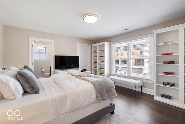 bedroom with hardwood / wood-style flooring, visible vents, and baseboards