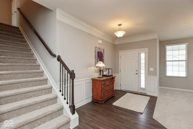 foyer entrance with ornamental molding and dark hardwood / wood-style flooring