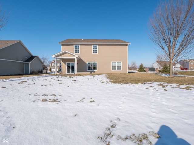 view of snow covered rear of property