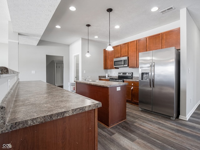 kitchen featuring sink, stainless steel appliances, dark hardwood / wood-style floors, decorative light fixtures, and kitchen peninsula