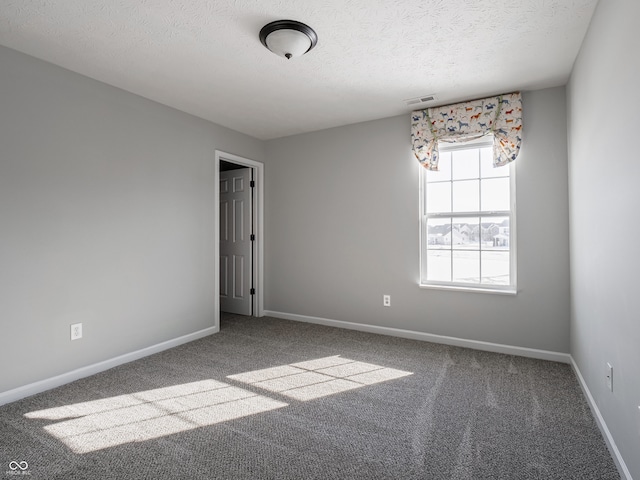 spare room featuring carpet floors and a textured ceiling