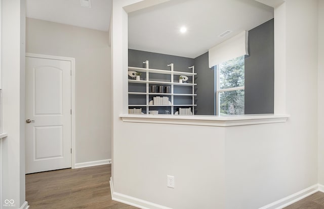 corridor with visible vents, baseboards, and wood finished floors