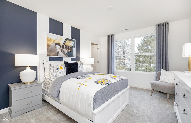 bedroom with light carpet, visible vents, and baseboards