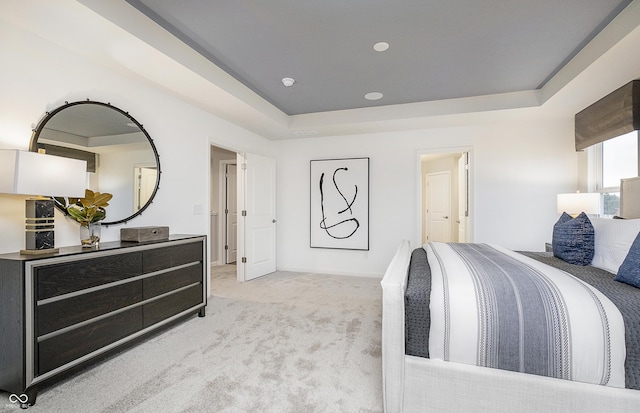 bedroom featuring light carpet and a tray ceiling