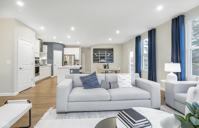 living area with light wood-style floors, recessed lighting, and baseboards