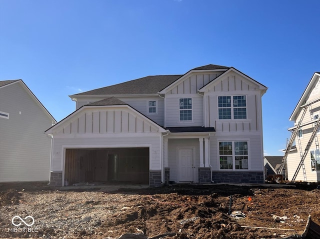 view of front of home with a garage, stone siding, and board and batten siding