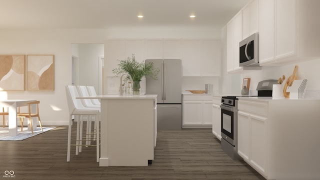 kitchen with a breakfast bar area, white cabinets, stainless steel appliances, dark wood-type flooring, and a center island with sink