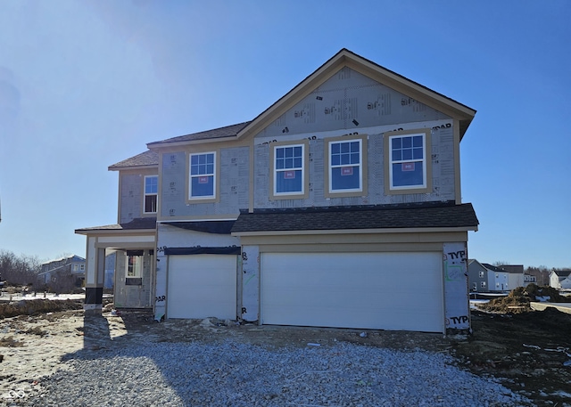 view of front of property with a garage, driveway, and a shingled roof