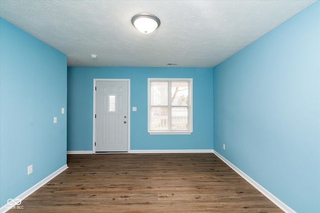 entrance foyer featuring dark wood-type flooring and a textured ceiling