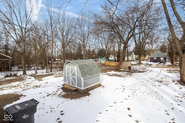 yard layered in snow with a storage unit