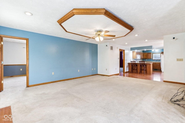 unfurnished living room with light carpet, recessed lighting, a ceiling fan, and baseboards