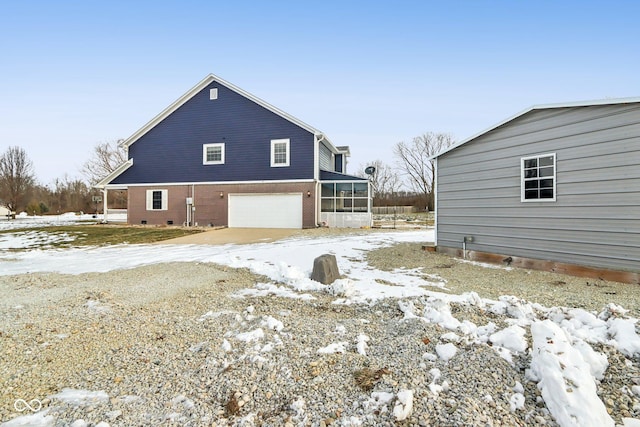 exterior space with crawl space, an attached garage, and a sunroom