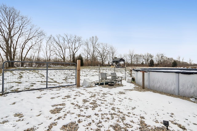 snowy yard featuring a covered pool and fence