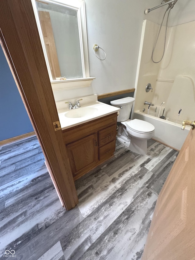 full bath featuring tub / shower combination, vanity, toilet, and wood finished floors