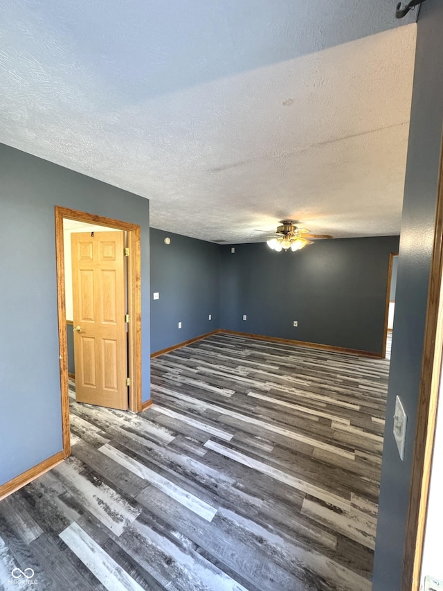 spare room featuring ceiling fan, a textured ceiling, baseboards, and wood finished floors