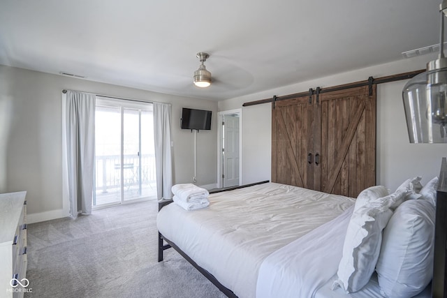 bedroom featuring ceiling fan, a barn door, carpet, and access to outside