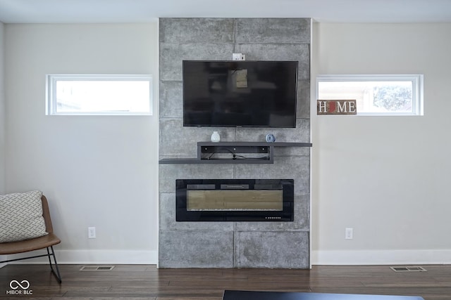 room details with a tiled fireplace and hardwood / wood-style floors