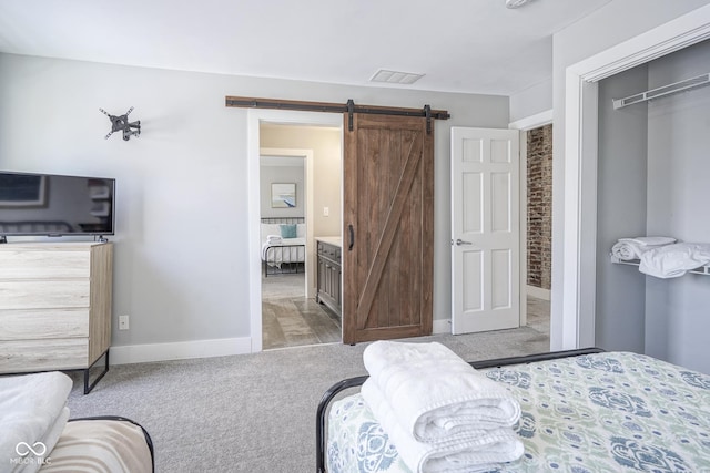 carpeted bedroom featuring a barn door and a closet