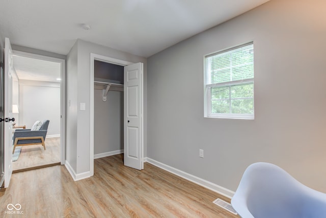 bedroom with a closet and light hardwood / wood-style flooring