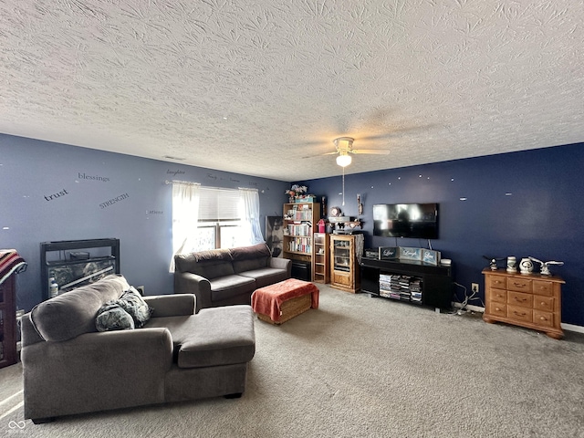 living room with ceiling fan, carpet, and a textured ceiling