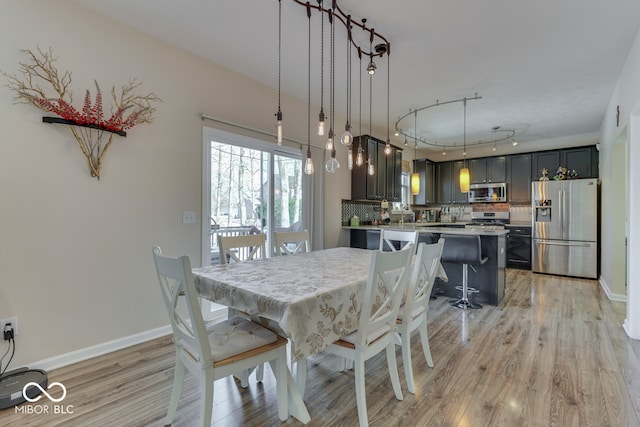 dining space featuring light hardwood / wood-style floors and rail lighting