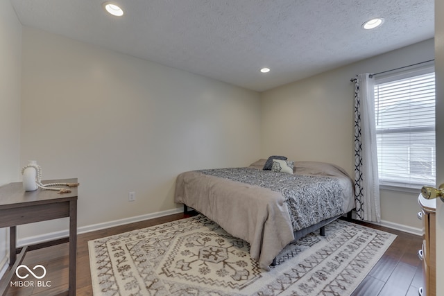 bedroom featuring dark wood-type flooring and a textured ceiling