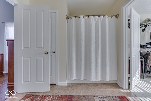 bathroom with tile patterned flooring and shower / bath combo with shower curtain