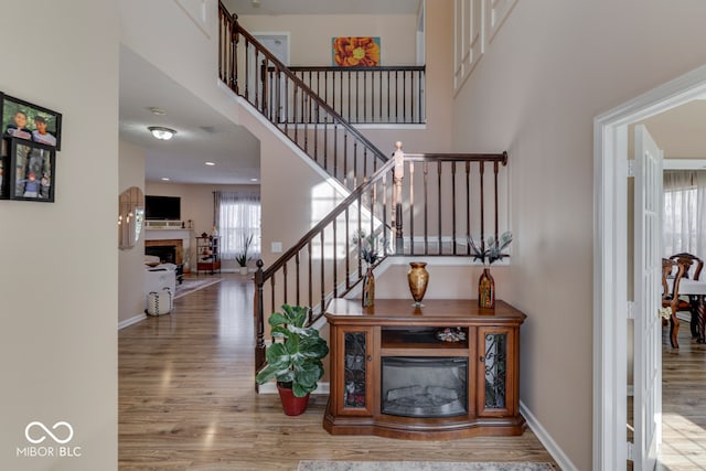 staircase featuring hardwood / wood-style floors and a towering ceiling