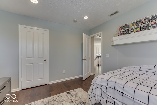 bedroom with dark hardwood / wood-style flooring and a textured ceiling