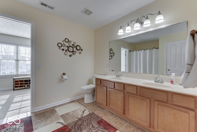 bathroom with tile patterned flooring, vanity, and toilet