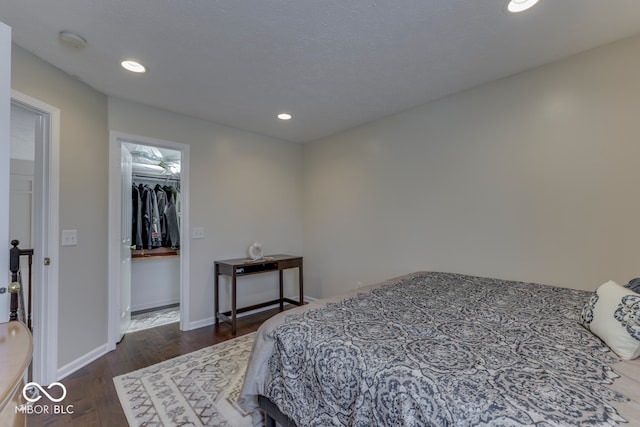 bedroom featuring a textured ceiling and dark hardwood / wood-style flooring