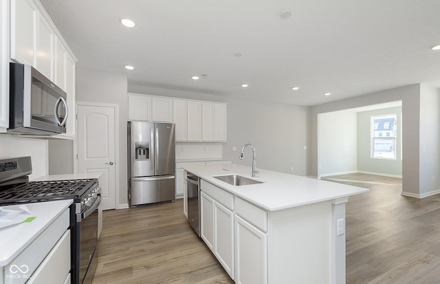 kitchen featuring sink, a center island with sink, white cabinets, and appliances with stainless steel finishes