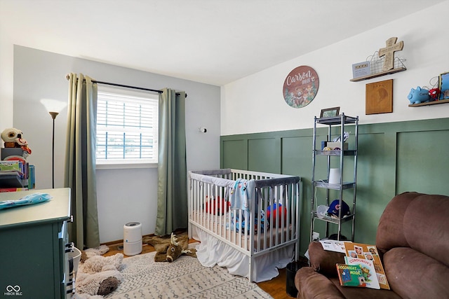 bedroom with hardwood / wood-style floors and a crib