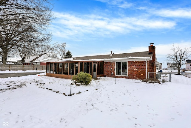 snow covered house with a sunroom