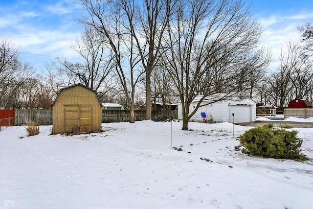 yard covered in snow featuring a shed