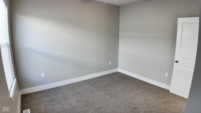 unfurnished room with dark colored carpet